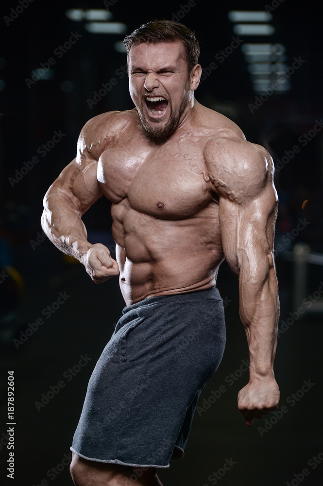 Fototapeta premium Brutal strong bodybuilder athletic men pumping up muscles with dumbbells.