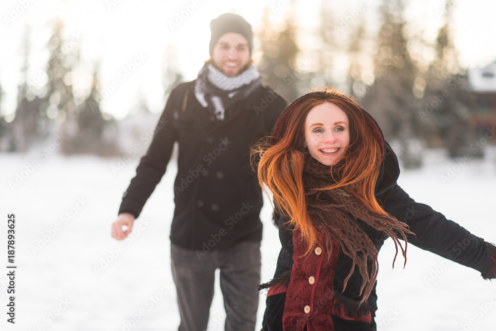 Cheerful girlfriend holding her man's hand while running Cheerful girlfriend holding her man's hand while running