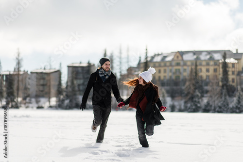 Young joyful couple enjoying the winter season