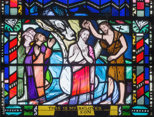 LONDON, GREAT BRITAIN - SEPTEMBER 16, 2017: The Babtism of Jesus cene on the stained glass in church St Etheldreda by Charles Blakeman (1953 - 1953).