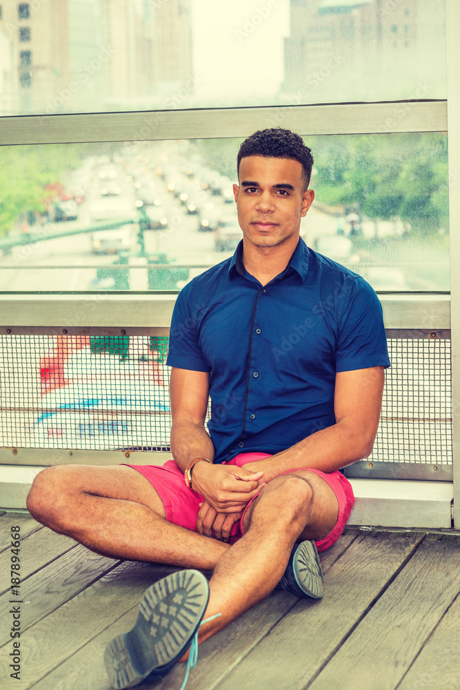 Young African American Man. Wearing blue short sleeve shirt, red