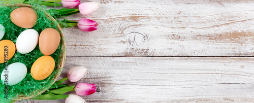Pink Tulips and real eggs for Easter on rustic white wooden background