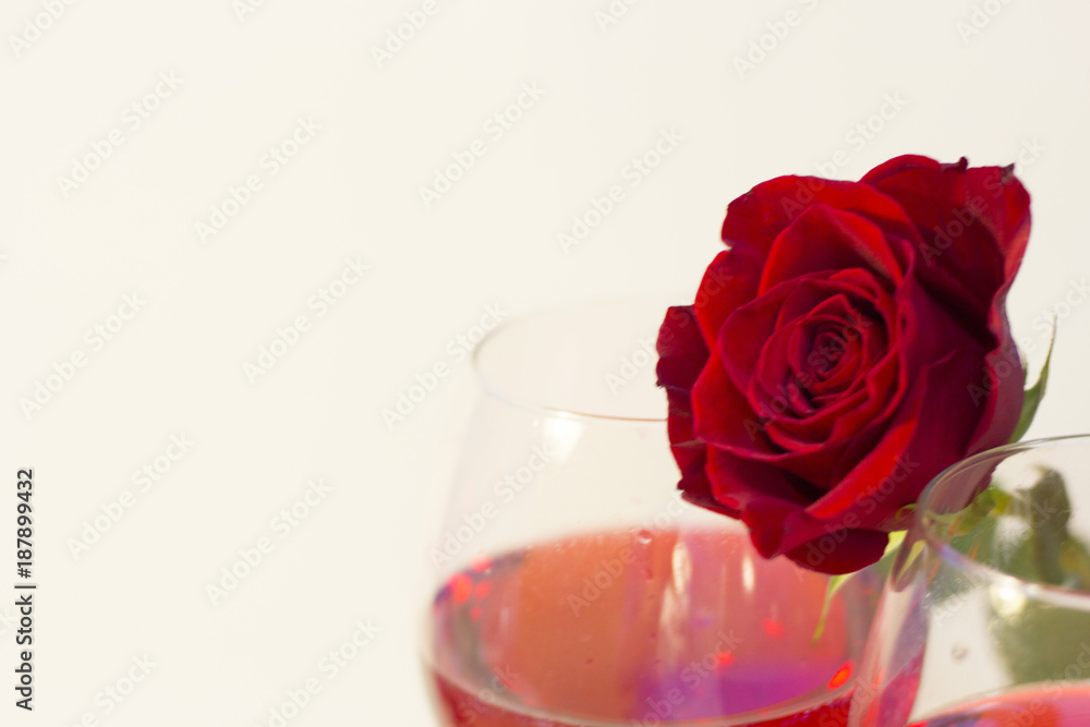 The concept of Love, Wedding, Proposal, Anniversary. with a glass of red wine and a beautiful red velvet rose, light background, close up The concept of Love, Wedding, Proposal, Anniversary. with a glass of red wine and a beautiful red velvet rose, light background, close up