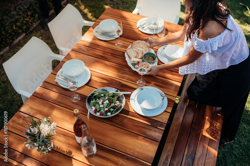 Картината върху платно Woman setting food on table for housewarming
