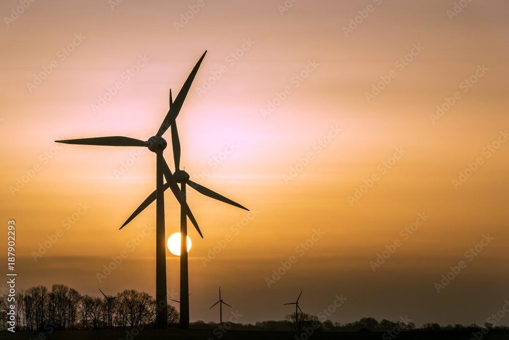Wind turbines (alternative energy source) as silhouette during sunrise. Concept: Renewable Energies Wind turbines (alternative energy source) as silhouette during sunrise. Concept: Renewable Energies