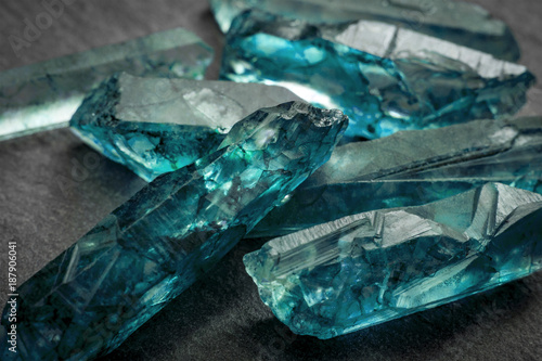 Aquamarines  and raw crystal gems concept with closeup of a bunch of blue uncut aquamarine, topaz or tourmaline crystals