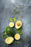 Food background with green vegetables: avocado, spinach, chavran leaves, red pepper and lemon on a dark old slate, stone or concrete background. Selective focus. Top view.Space for text.