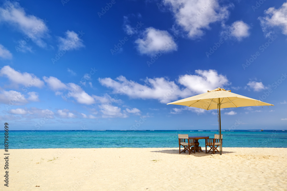 Table, chairs and umbrella on sand beach in Mauritius Island