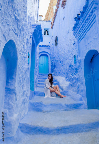 Beautiful girl in a white dress against a blue city Chefchaouen, Morocco © Olena Zn