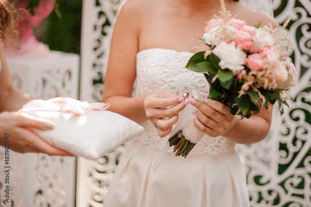 Bride dressed in a beautiful white wedding dress holding a ring Bride dressed in a beautiful white wedding dress holding a ring