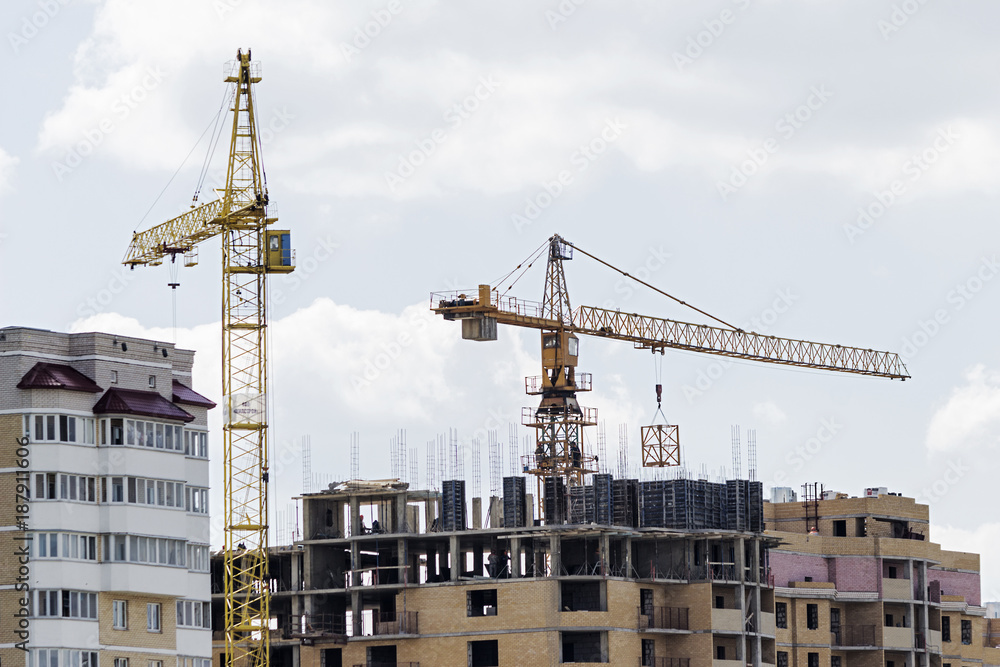 construction cranes and a line of a multistory building