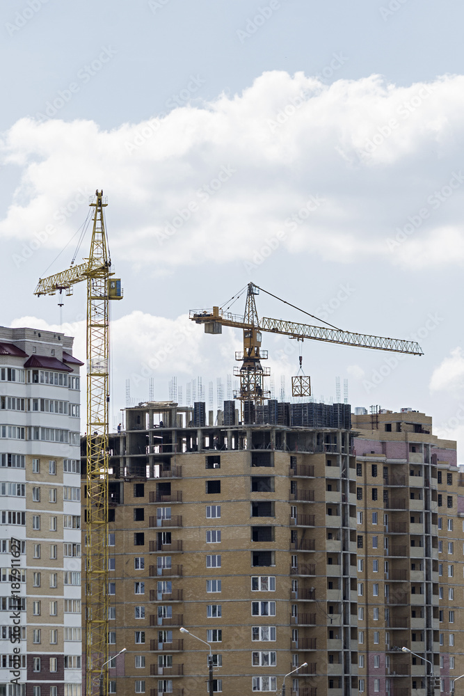 construction cranes and a line of a multistory building construction cranes and a line of a multistory building