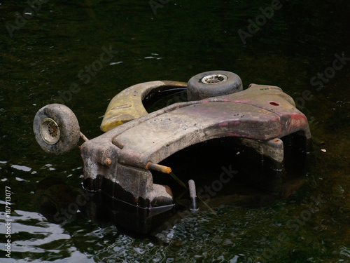 abandoned childrens toy buggy in a drained canal photo