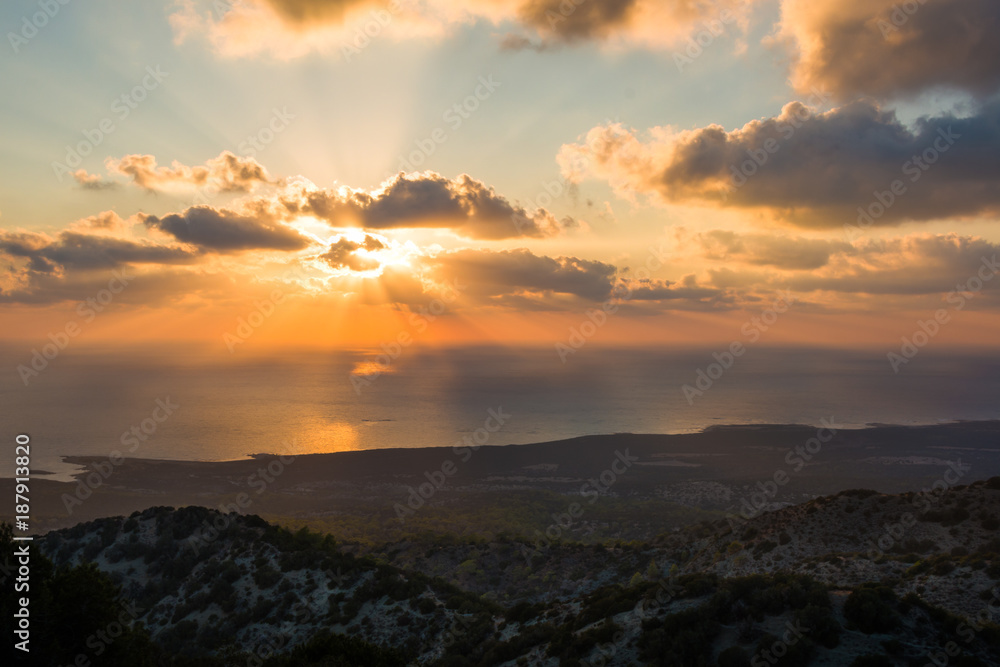 Obraz premium Sunrays of evening sun behind clouds at Cyprus coast HDR landscape.