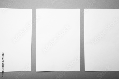 Three white sheets of A4 format in a row on a gray background, design options. Mock-up.