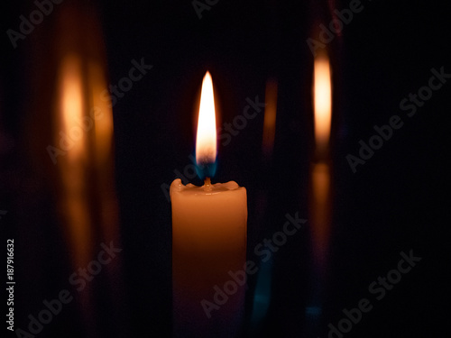 on a black background bright yellow candles, a holiday or a church burn