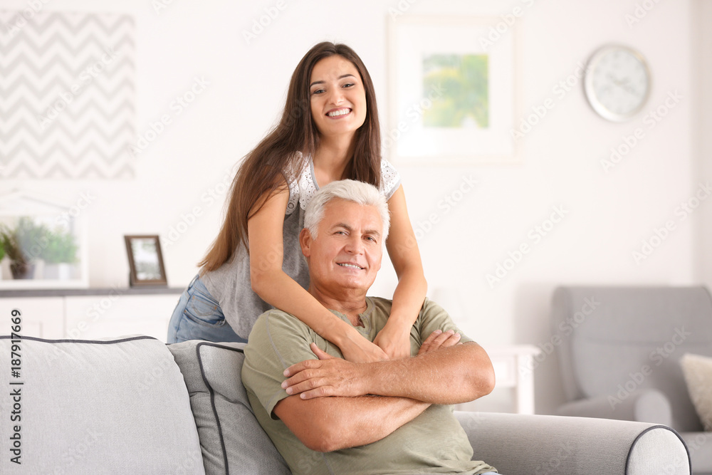 Mature man with daughter in comfortable room