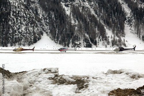 Three helicopters on a row in the airport of St Moritz Switzerland in the alps
