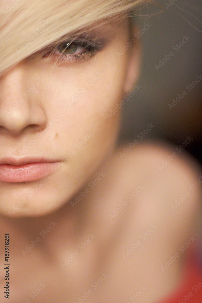Close-up portrait of beautiful fashionable blonde girl with green eyes, indoors