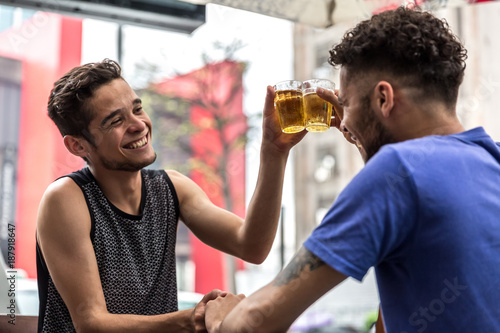 Konstfotografi Homosexual Couple Raising a Toast with Beer in Bar