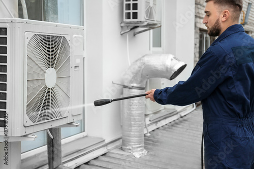 Wallpaper Mural Male technician cleaning air conditioner outdoors Torontodigital.ca