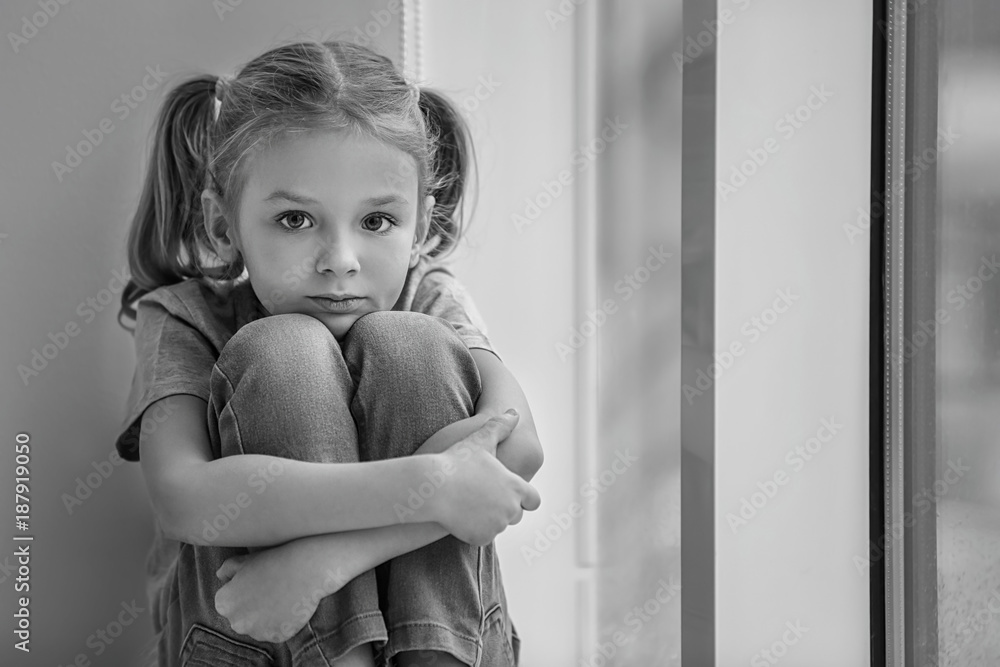 Sad little girl sitting on windowsill, black and white effect Stock ...