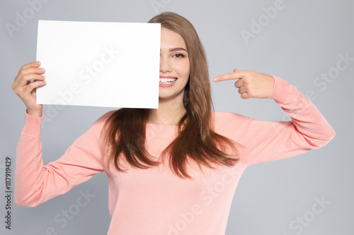 Young woman with blank shee...