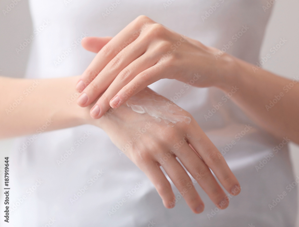 Young woman applying hand cream, closeup Young woman applying hand cream, closeup