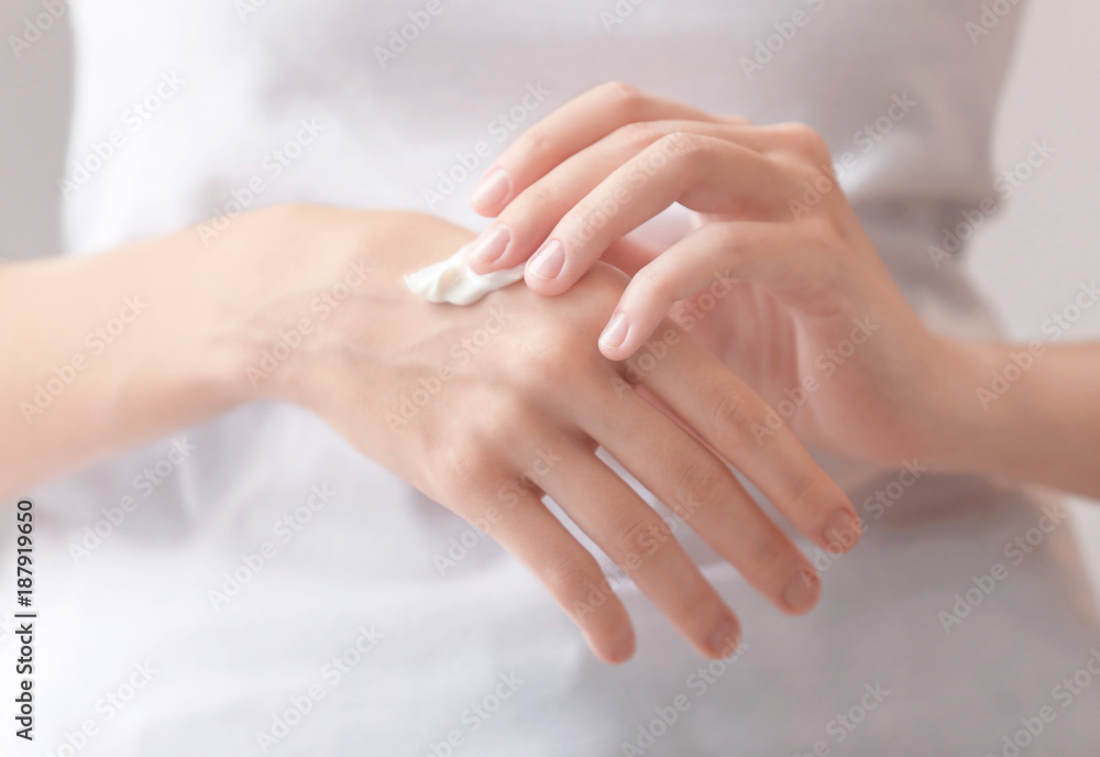 Young woman applying hand cream, closeup Young woman applying hand cream, closeup