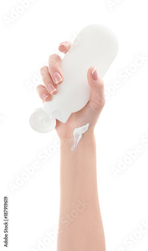 Young woman holding bottle of cream in hand on white background