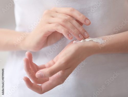 Young woman applying hand cream  closeup