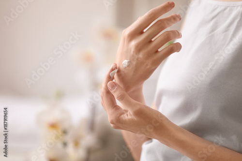 Young woman applying hand cream  closeup