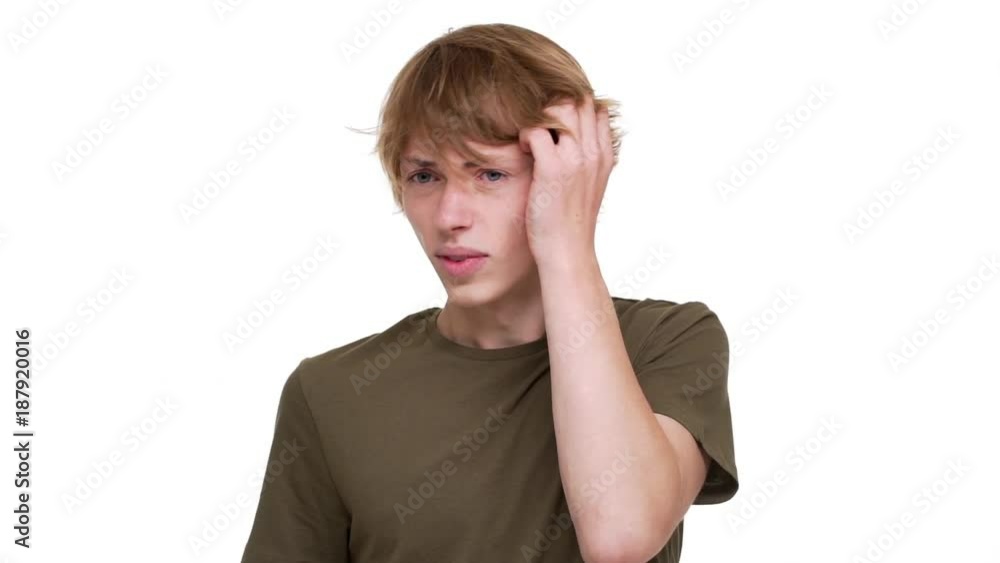Horizontal portrait of tense blond man grabbing his head being stressed thinking about solution of problem over white wall in slow motion. Concept of emotions Horizontal portrait of tense blond man grabbing his head being stressed thinking about solution of problem over white wall in slow motion. Concept of emotions