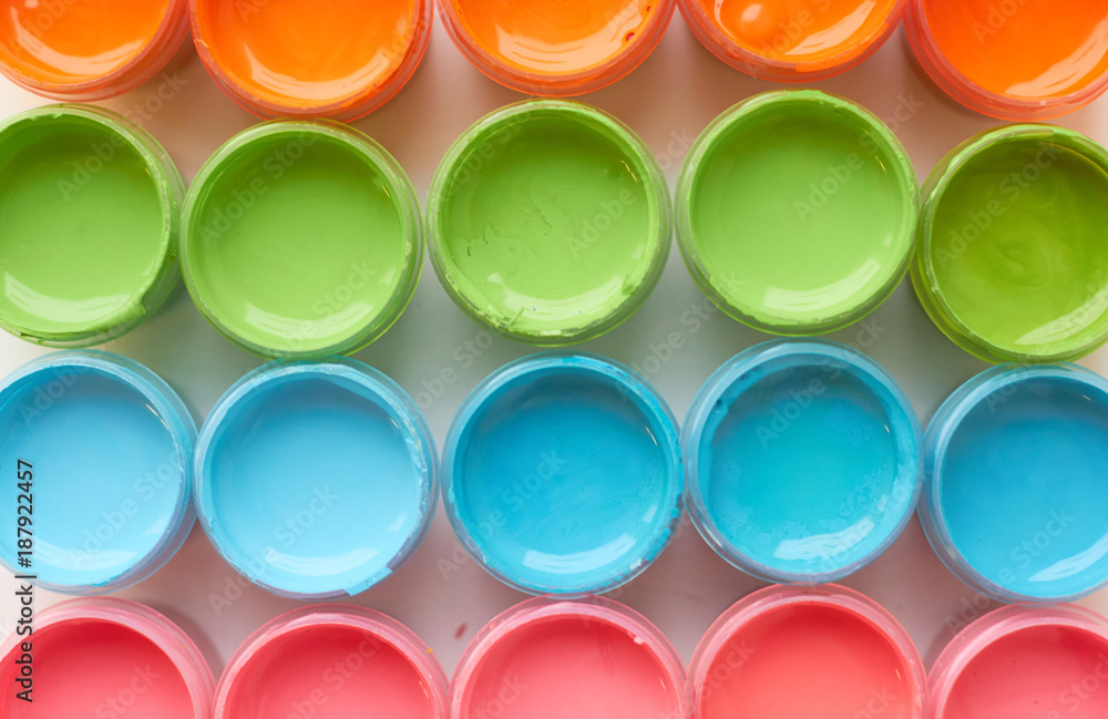 Many open cans with bright colored paints. Many open cans with bright colored paints.