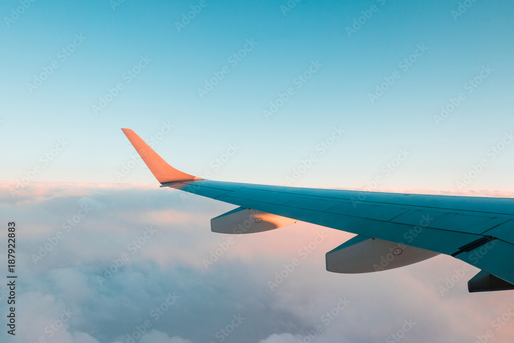 Fototapeta premium Golden light hitting the aircraft wing in flight.