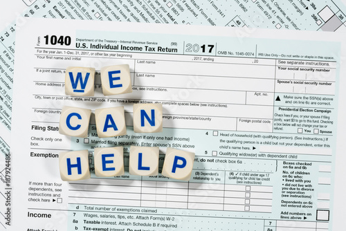 Macro close up of 2017 IRS form 1040 with WE CAN HELP letters photo