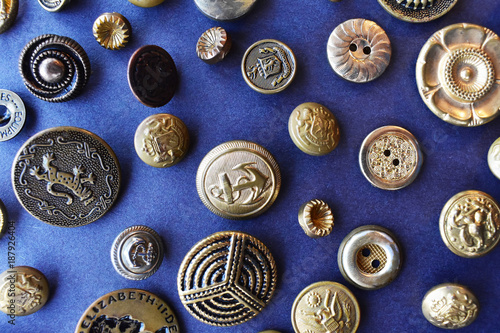 gold sewing buttons from above on blue