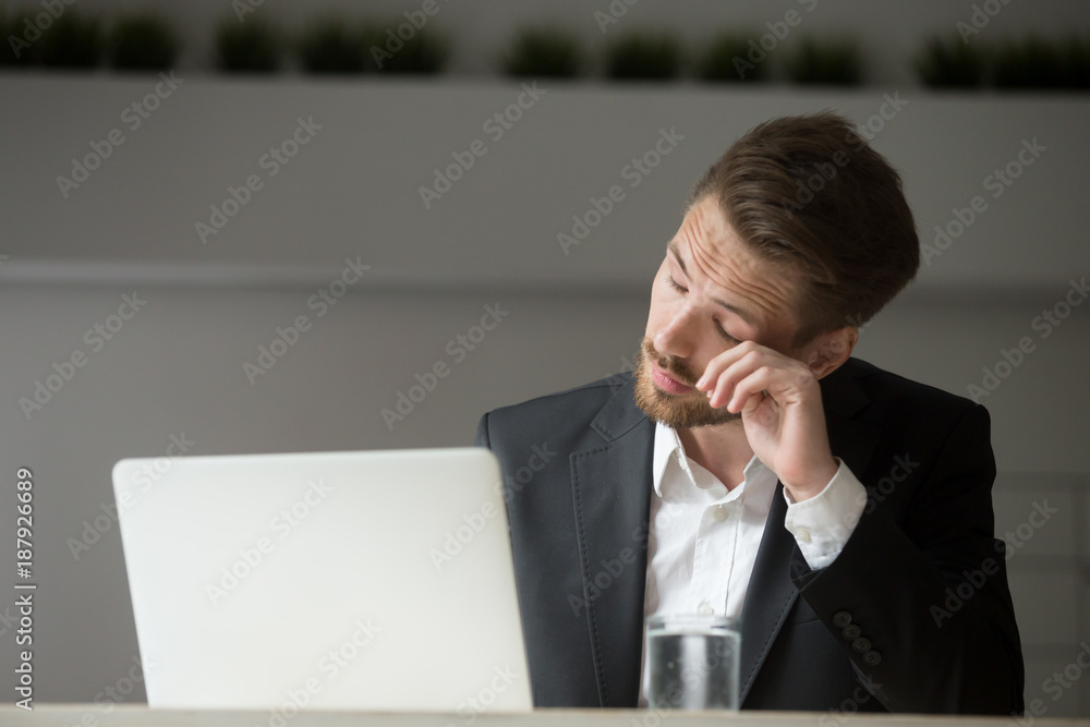 Overworked businessman in suit tired from laptop work, exhausted man feeling lack of sleep, headache or eye strain at workplace, office worker suffering from chronic fatigue after long using computer Overworked businessman in suit tired from laptop work, exhausted man feeling lack of sleep, headache or eye strain at workplace, office worker suffering from chronic fatigue after long using computer