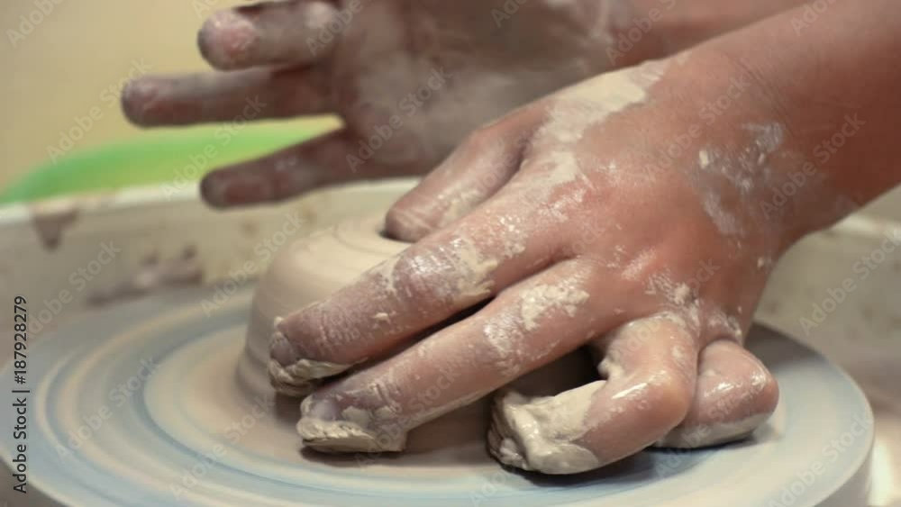 child hands making a clay pottery
child hands making a clay pottery