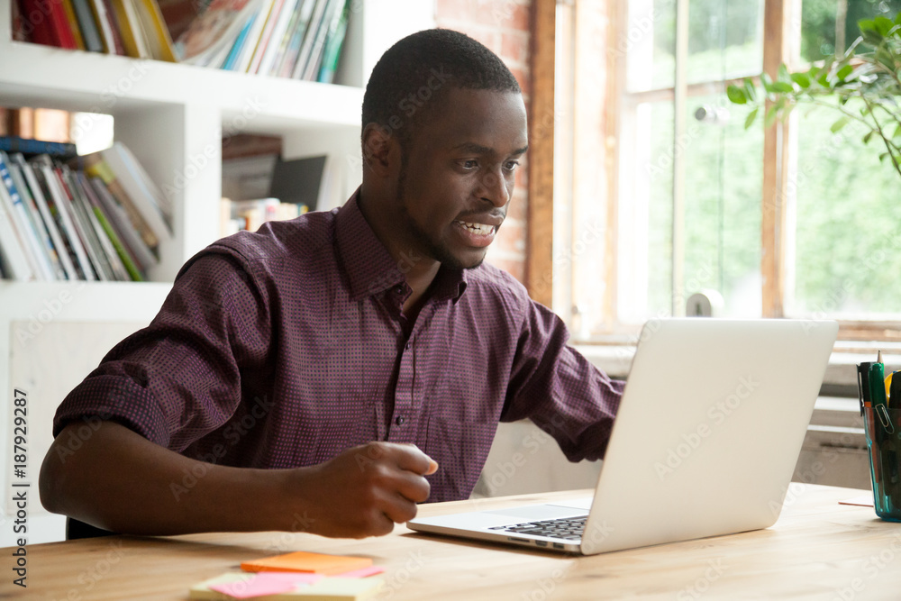 Εκτύπωση καμβά African businessman looking at laptop screen frustrated by bad news, stressed ma