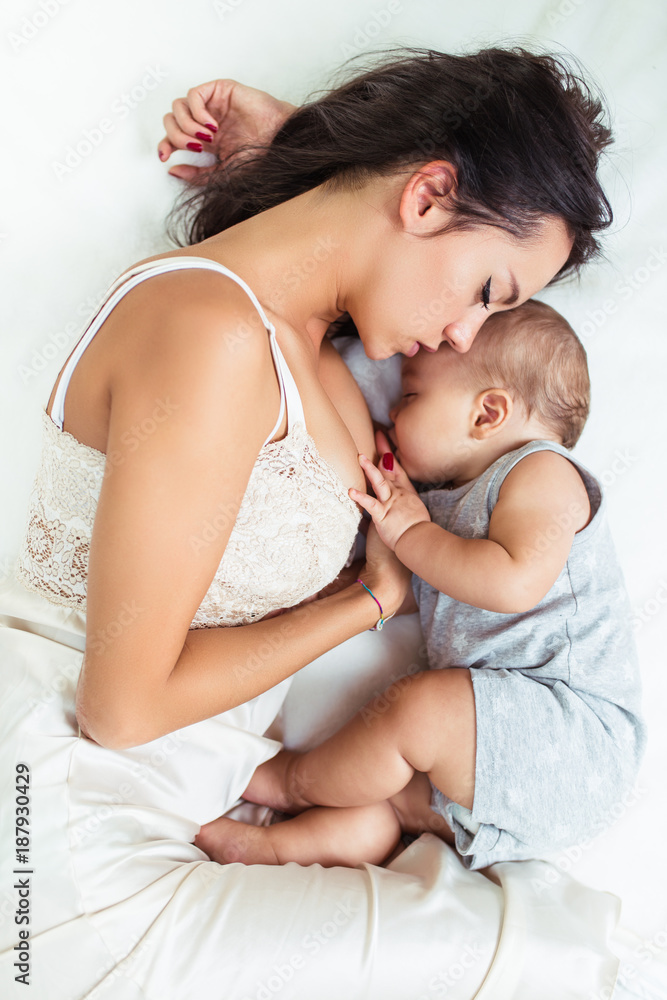 Beautiful mother and cute little baby boy sleeping together on bed. Beautiful mother and cute little baby boy sleeping together on bed.