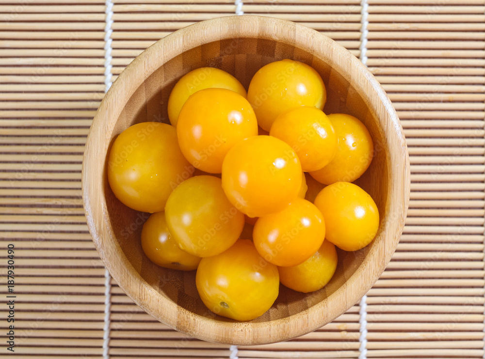 yellow cherry tomatoes in a wooden bowl yellow cherry tomatoes in a wooden bowl