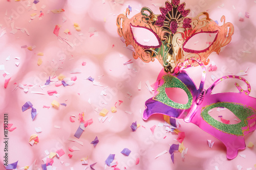 Table top view aerial image of beautiful couple carnival mask background.Flat lay essential accessory on modern rustic pink wallpaper at home office desk studio. Copy space for creative design text.