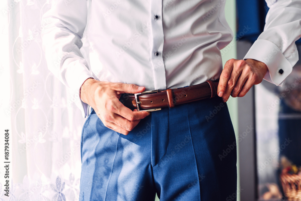 Business man or groom dressing up with leather strap. Business man or groom dressing up with leather strap.