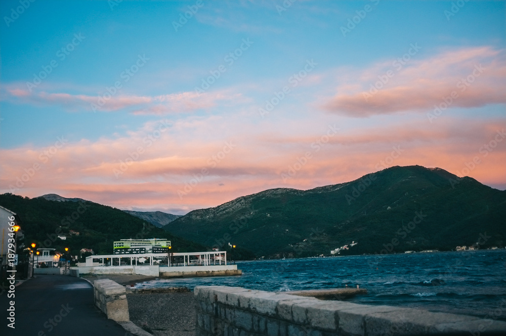 The boat in the sea at sunset with mountains in the background. The Bay of Kotor. Montenegro. The boat in the sea at sunset with mountains in the background. The Bay of Kotor. Montenegro.