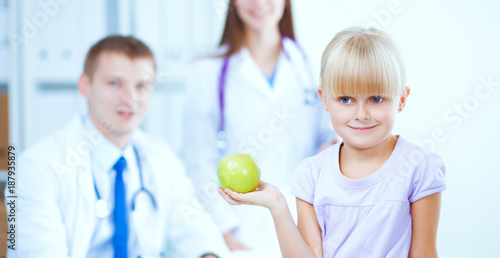 Female doctor examining child with stethoscope at surgery