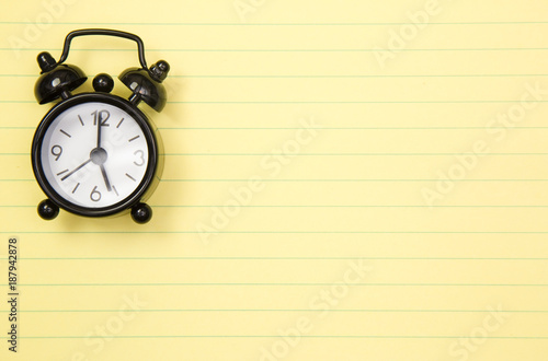 Background of a Simple Yellow Legal Pad with Classic Black Alarm Clock
