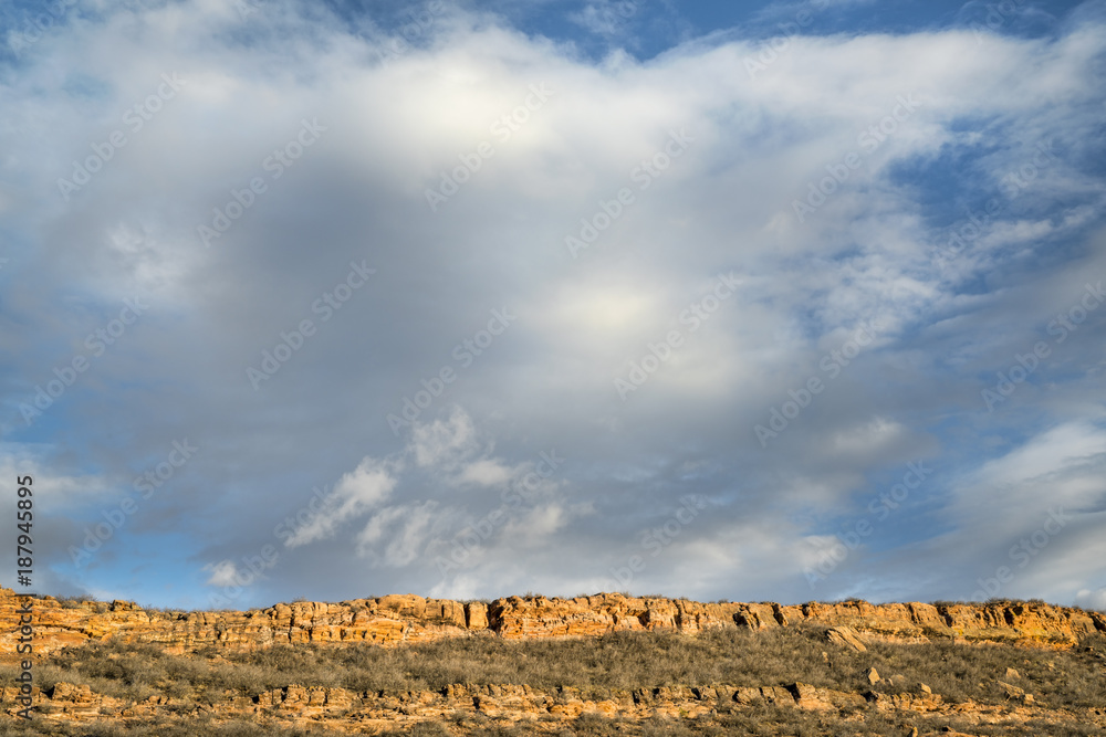 Naklejka premium clouds over sandstone cliff