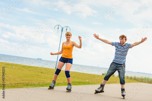 Young couple on roller skates riding outdoors