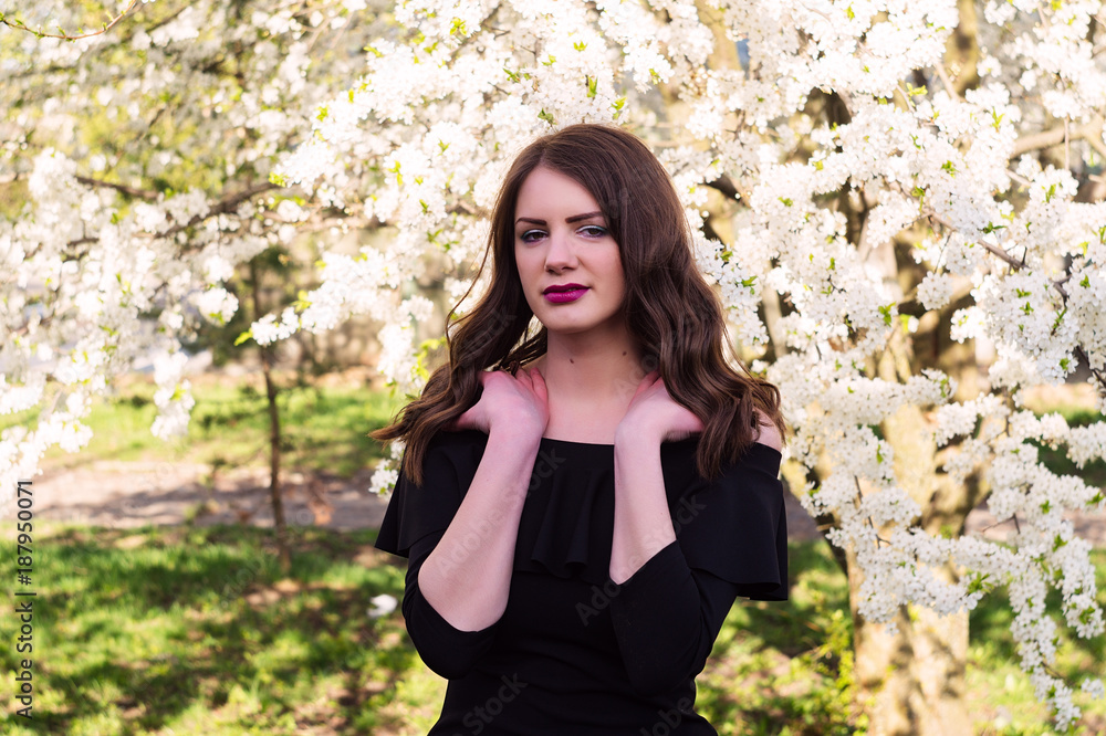 Portrait of a girl in the spring in a white delicate blossom.